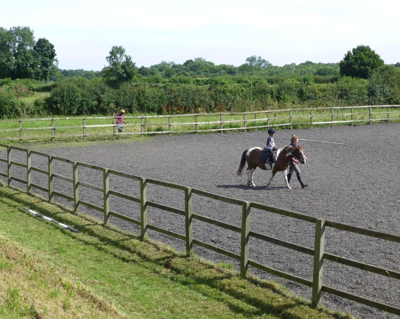 A rider on the lead rein in an outdoor arena